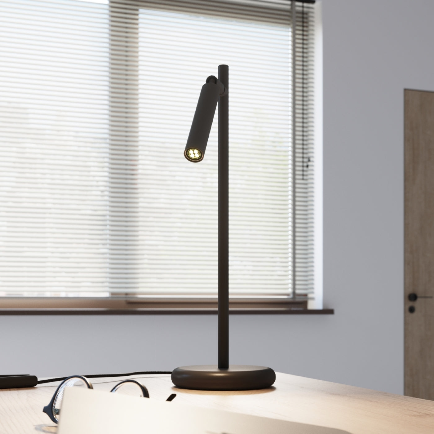 Modern table lamp by Solstånd with warm glow on a wooden desk