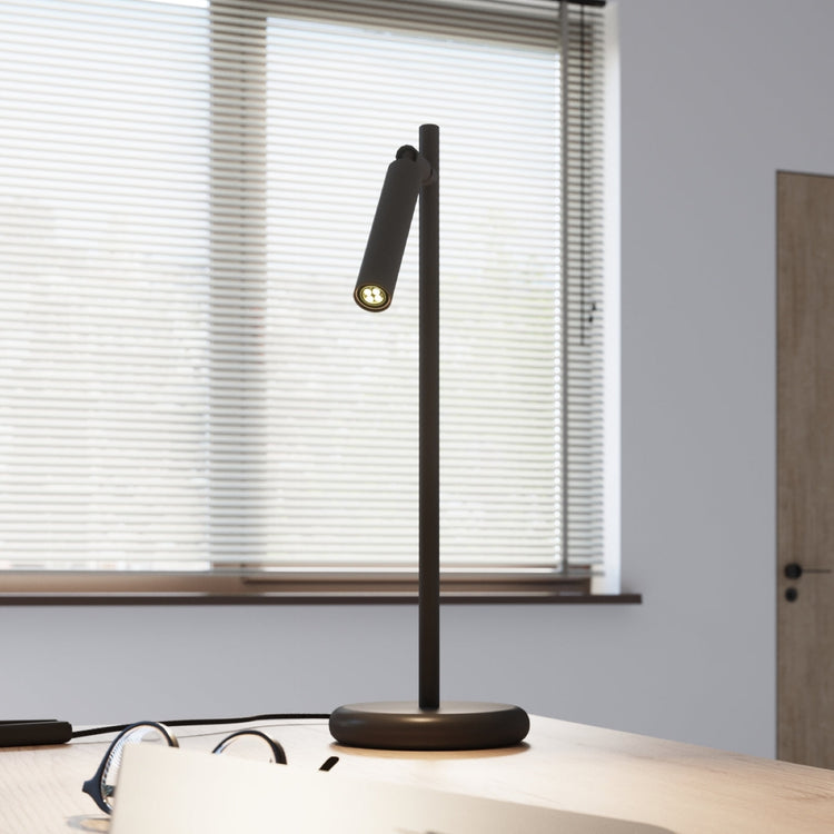 Modern table lamp by Solstånd with warm glow on a wooden desk